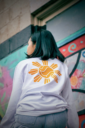 Manila SUN on back of white long sleeve & Red/Blue FLOW on front